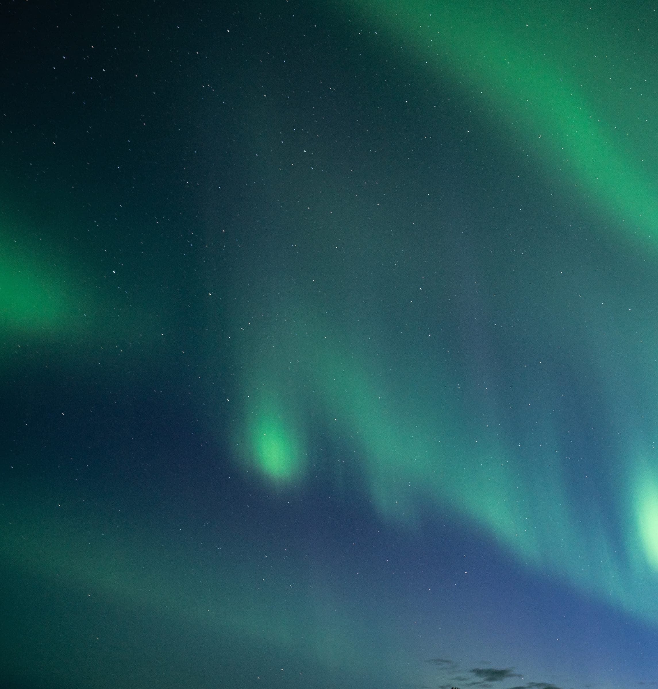Auroras boreales verdes cruzando un cielo estrellado